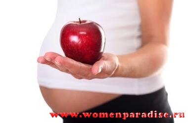 Беременная женщина с яблоком